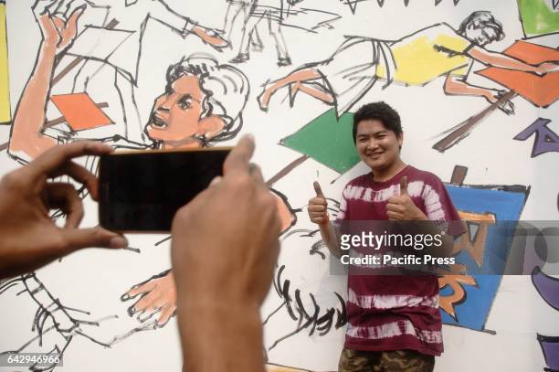 Student poses for a photo in front of a newly made Mural at a wall of the Central Shahid Minar as part of the observance of for International Mother...