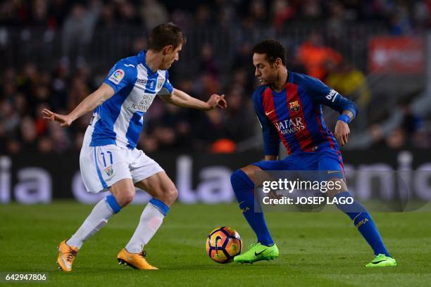 Leganes' Argentinian midfielder Alexander Szymanowski vies with Barcelona's Brazilian forward Neymar during the Spanish league football match FC...