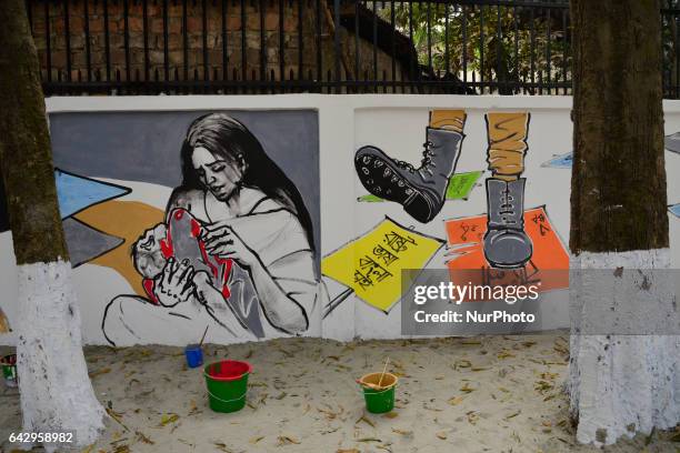 Bangladeshi fine arts students and teachers paints on a wall in front of the Central Shahid Minar , in Dhaka on February 19 as part of preparations...