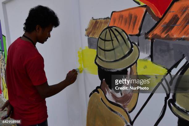 Bangladeshi fine arts students and teachers paints on a wall in front of the Central Shahid Minar , in Dhaka on February 19 as part of preparations...