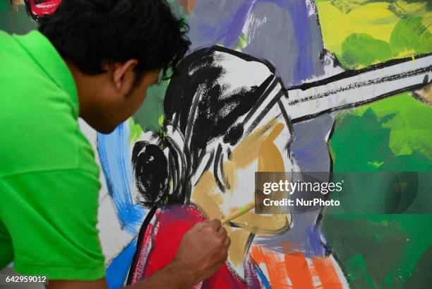 Bangladeshi fine arts students and teachers paints on a wall in front of the Central Shahid Minar , in Dhaka on February 19 as part of preparations...