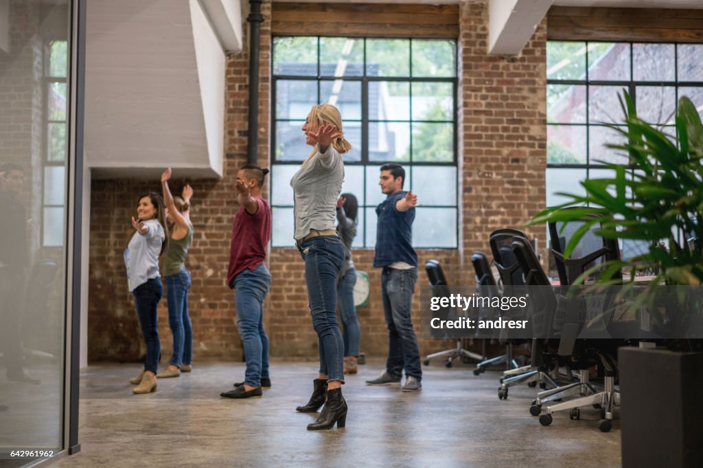 Group of workers exercising at the office