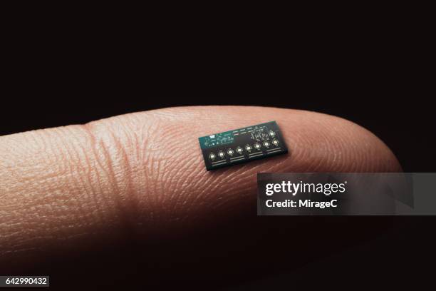 computer chip on tip of finger - nanotecnología fotografías e imágenes de stock