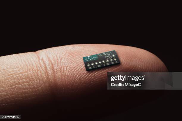 computer chip on tip of finger - nanotechnologie photos et images de collection