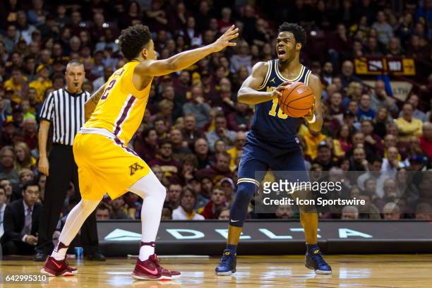 Michigan Wolverines guard Derrick Walton Jr. Yells while Minnesota Golden Gophers guard Nate Mason defends during the Big Ten Conference game between...