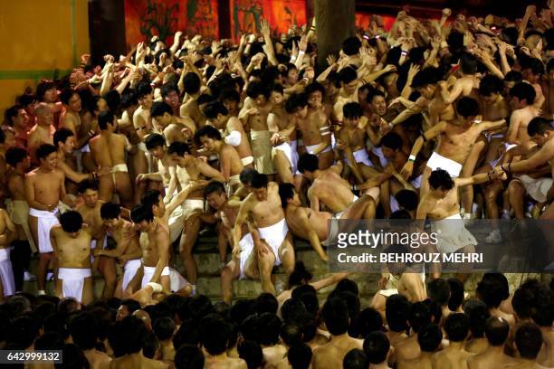 In this picture taken on February 18 worshippers fall down the stairs while waiting for the priest to throw the sacred batons during the annual Naked...