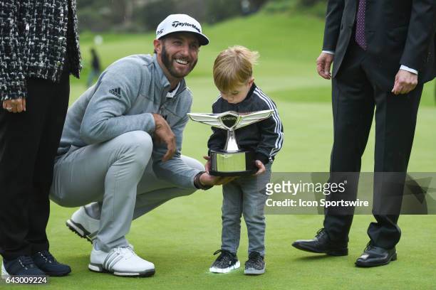 Dustin Johnson's son Tatum Gretzky Johnson helps hold up the trophy after winning the Genesis Open golf tournament at the Riviera Country Club on...