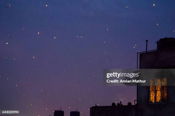 lit window against a sky full of lanterns - sky-lantern stock pictures, royalty-free photos & images