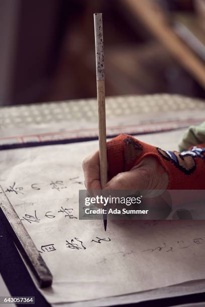 elderly japanese woman writing calligraphy, close up of hand - japansk skrift bildbanksfoton och bilder