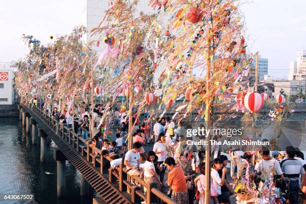 People throw the Tanabata ornaments from Kannonbashi Bridge on July 7, 1998 in Tsu, Mie, Japan.