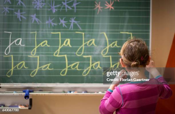 Girl is practicing writing on a blackboard. Lesson at a school in Goerlitz on February 03, 2017 in Goerlitz, Germany.