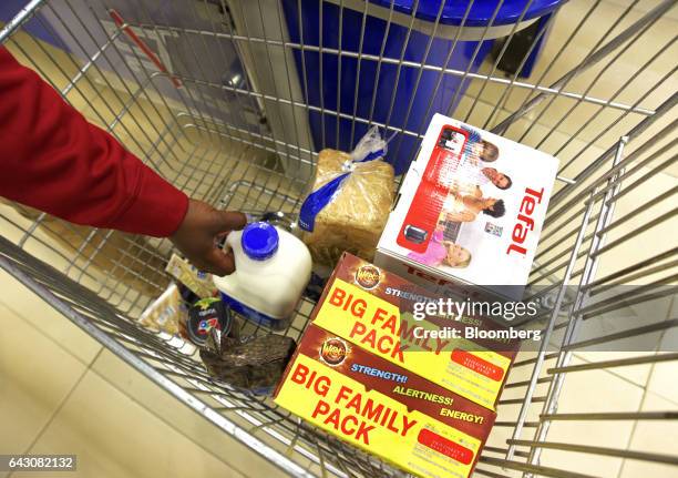 An employee reaches into a customer's shopping cart at the check-out area inside a Nakumatt Holdings Ltd. Supermarket in Nairobi, Kenya, on Saturday,...