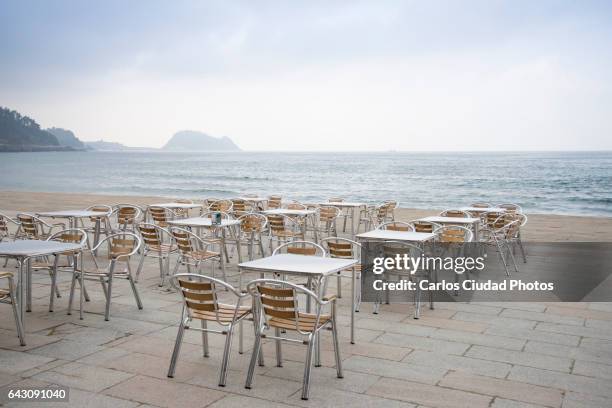 empty chairs and tables in front of the cantabrian sea, zarautz, basque country - cafe table chair outside stock pictures, royalty-free photos & images