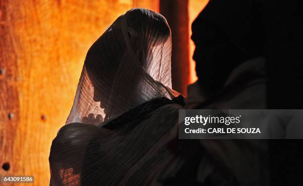 An Ethiopian Orthodox Christian female pilgrim is pictured at a mass before the annual festival of Timkat in Lalibela, Ethiopia which celebrates the...