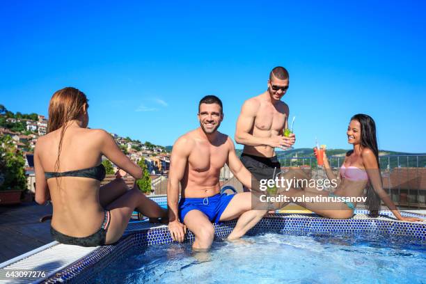young people drinking cocktails on rooftop swimming pool - hot tub party stock pictures, royalty-free photos & images