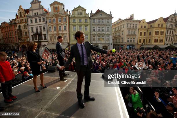 Roger Federer of Switzerland hits tennis balls into the crowd as Tomas Berdych of The Czech Republic and the Mayor of Prague Adriana Krnacova look on...