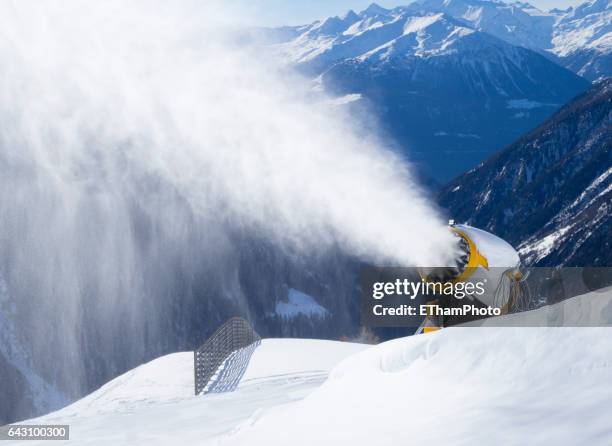 snow cannon (snow gun) is spraying artificial snow onto ski slope - fake snow stock pictures, royalty-free photos & images