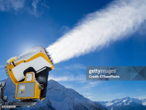 snow cannon (snow gun) is spraying artificial snow onto ski slope - sneeuwmachine stockfoto's en -beelden