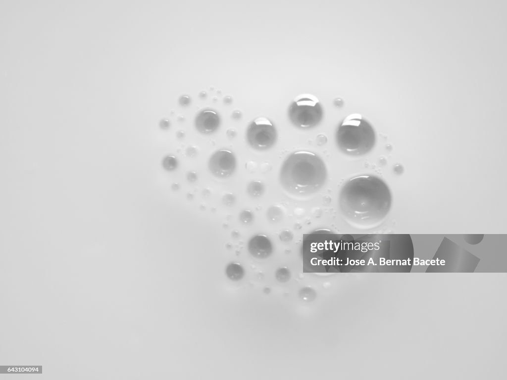 Full frame of the textures formed by the bubbles in the shape of circle floating on a liquid white color background