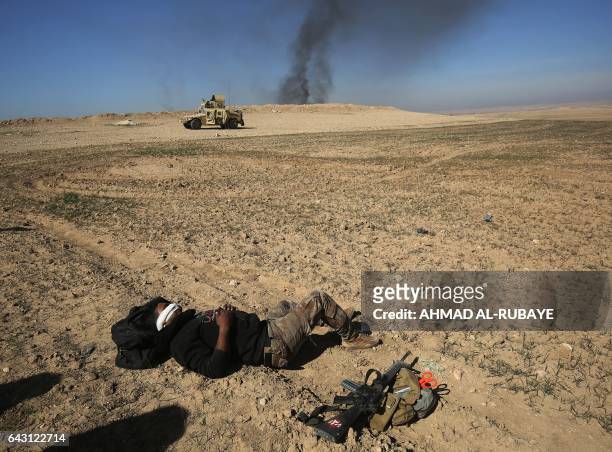 An Iraqi soldier lies on the ground awaiting to be evacuated, after he was wounded in an explosives-laden vehicle attack claimed by Islamic State...
