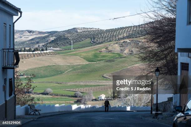 old man walking down hill through town in southern spain - evergreen cemetery stock pictures, royalty-free photos & images
