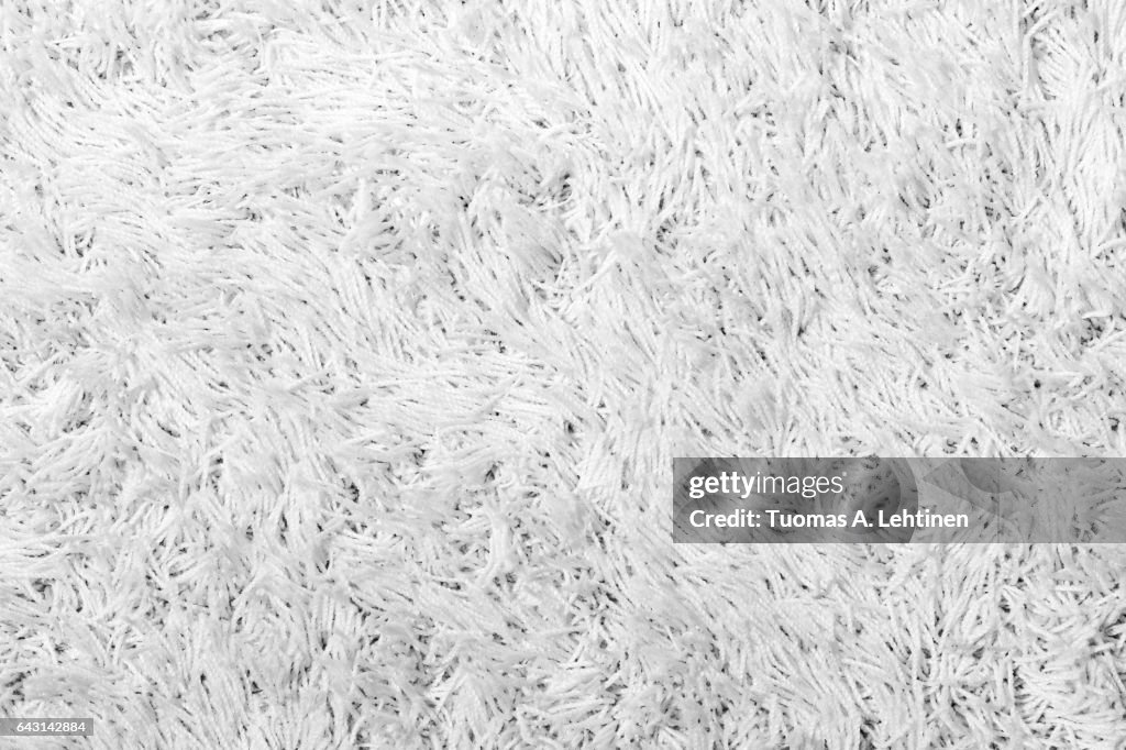 Closeup of a white shaggy carpet texture in black&white.