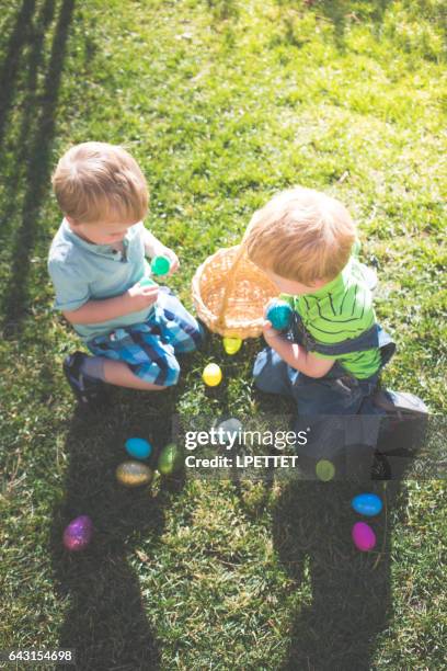 easter egg hunt with twins - easter hunt stock pictures, royalty-free photos & images