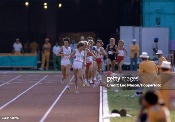Mary Decker of the USA trips and falls into the infield whilst Budd , competing for Great Britain, looks on during the final of the Women's 3000...
