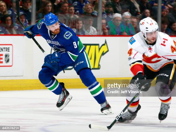 Jack Skille of the Vancouver Canucks and Matt Bartkowski of the Calgary Flames skate up ice during their NHL game at Rogers Arena February 18, 2017...
