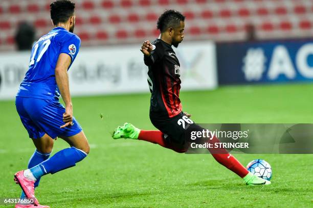 Abdulaziz Haikal of UAE's Al-Ahli FC kicks the ball past Ali Ghorbani of Iran's Esteghlal FC during their AFC Champions League qualifying football...