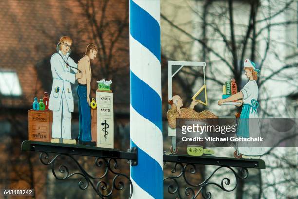 Munich, Germany A maypole designed with scenes from hospital with a doctor examining a patient a a nurse visiting an ill man at his hospital bed on...