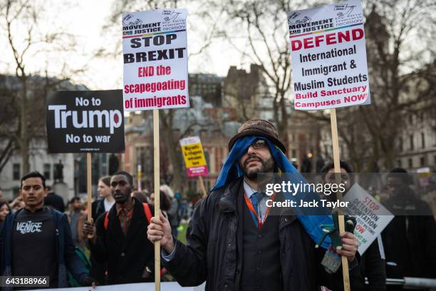 Protesters hold up placards during a rally in Parliament Square against US President Donald Trump's state visit to the UK on February 20, 2017 in...