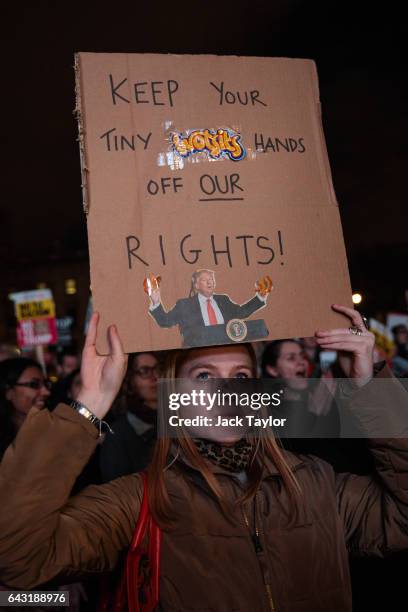 Protester looks up to the sky as they hold up a placard during a rally in Parliament Square against US President Donald Trump's state visit to the UK...