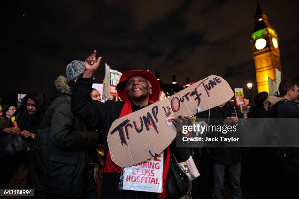 Protester looks up to the sky as they hold up a placard during a rally in Parliament Square against US president Donald Trump's state visit to the UK...