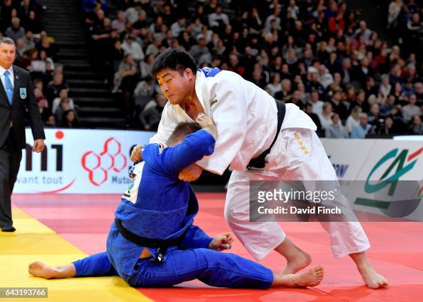 Takeshi Ojitani of Japan throws Andre Breitbarth of Germany with an inner leg hook for an ippon to win their o100kg round two contest during the 2017...