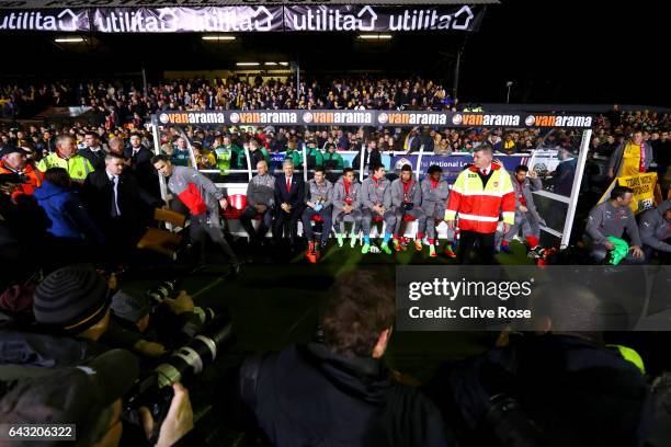 Arsene Wenger, manager of Arsenal sits on the bench with his coaching staff and substitutes before the Emirates FA Cup fifth round match between...