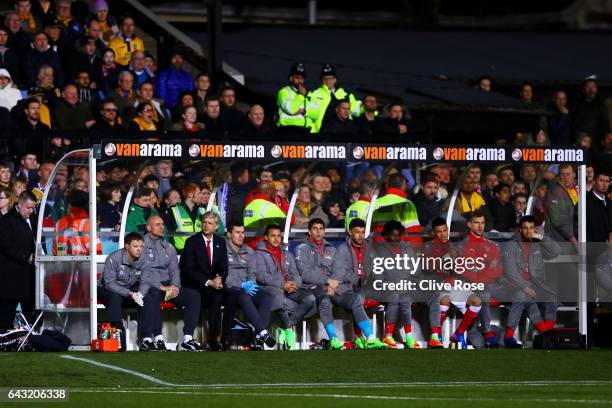 Arsene Wenger, manager of Arsenal sits on the bench with his coaching staff and substitutes before the Emirates FA Cup fifth round match between...