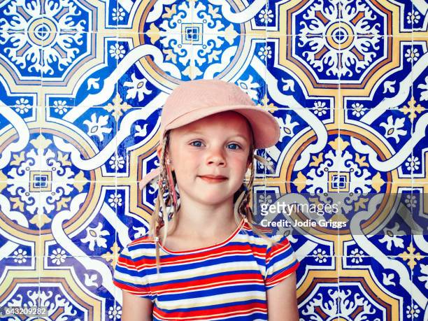 portrait of a young girl standing against a wall covered in patterned tiles - viana do castelo city stock pictures, royalty-free photos & images