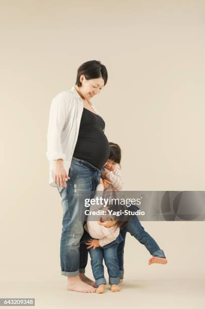 schwangere mutter und zwei schwestern im studio - 気にかける stock-fotos und bilder