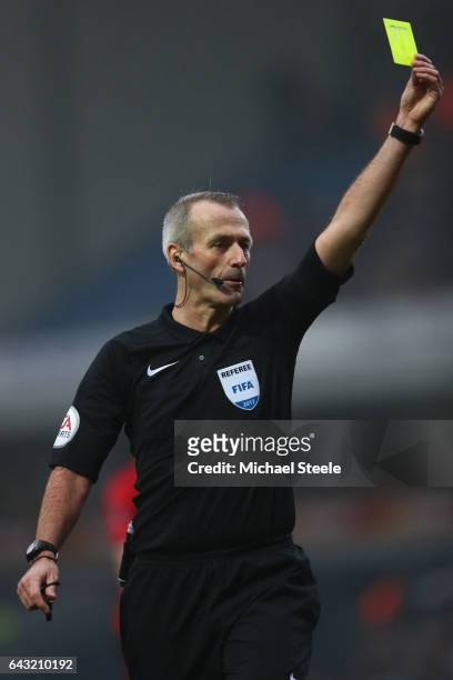Referee Martin Atkinson brandishes a yellow card during The Emirates FA Cup Fifth Round match between Blackburn Rovers and Manchester United at Ewood...