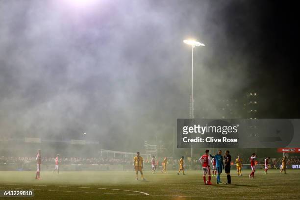 David Ospina of Arsenal speaks with referee Michael Oliver as smoke from a smoke bomb fills the air during the Emirates FA Cup fifth round match...