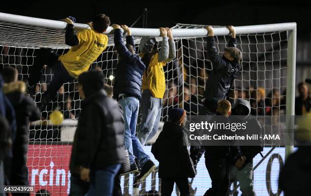 Sutton United fans hang of the goal crossbar after The Emirates FA Cup Fifth Round match between Sutton United and Arsenal on February 20, 2017 in...