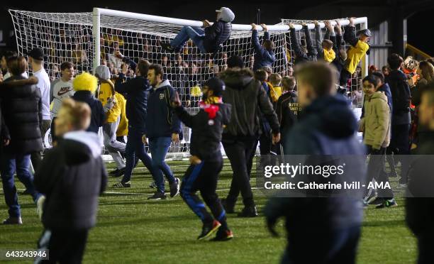 Sutton United fans hang of the goal crossbar after The Emirates FA Cup Fifth Round match between Sutton United and Arsenal on February 20, 2017 in...