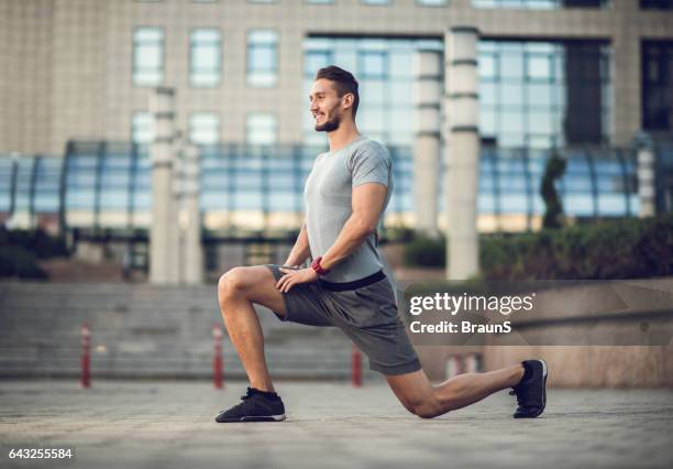 happy male athlete exercising lunges on the city street. - lunge imagens e fotografias de stock