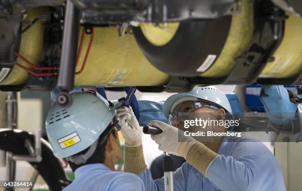 Toyota Motor Corp. Workers install hydrogen tanks to a Mirai fuel-cell vehicle on the production line of the company's Motomachi plant in Toyota...