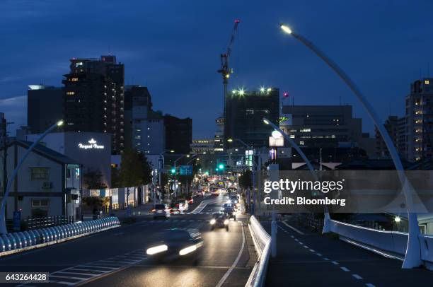 Traffic passes buildings illuminated at night in Toyota City, Aichi, Japan, on Thursday, Oct. 13, 2016. Toyota Motor Corp. Plans to rely on hydrogen...