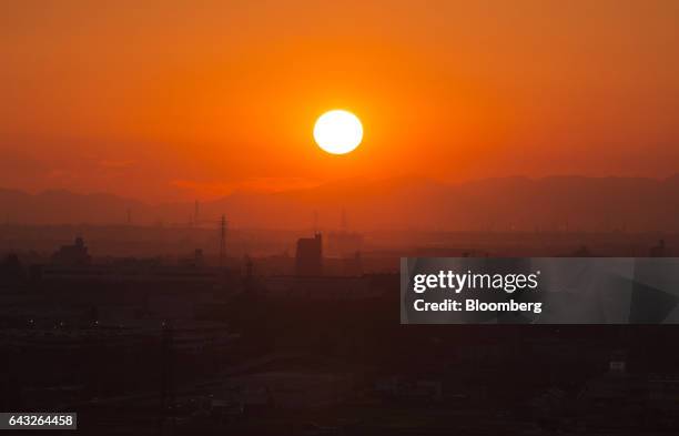 The sun sets behind buildings in Toyota City, Aichi, Japan, on Friday, Oct. 14, 2016. Toyota Motor Corp. Plans to rely on hydrogen to all but rid its...