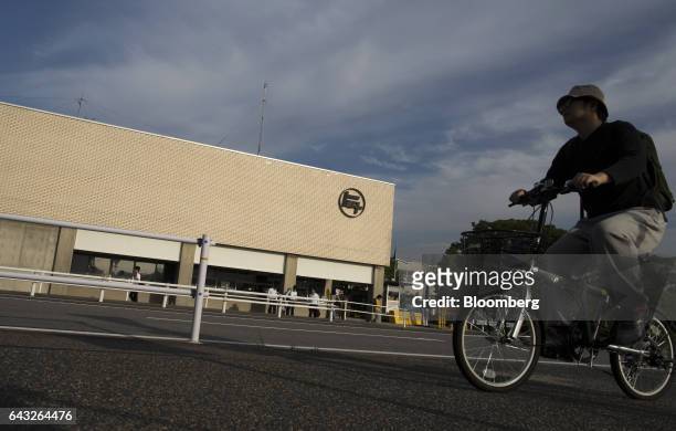 Worker rides a bicycle past the Toyota Motor Corp. Motomachi plant in Toyota City, Aichi, Japan, on Friday, Oct. 14, 2016. Toyota plans to rely on...