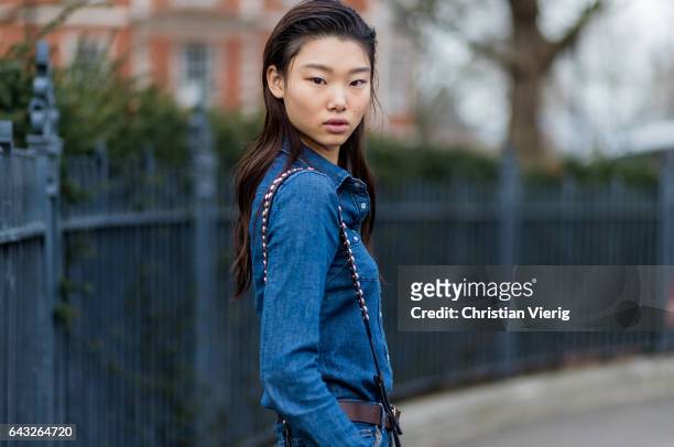 Model with wet hair look wearing a denim jeans shirt outside Christopher Kane on day 4 of the London Fashion Week February 2017 collections on...