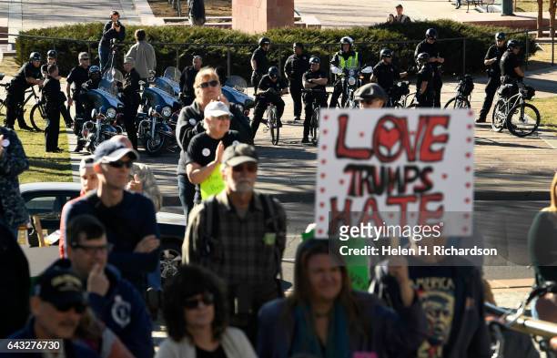 Denver police officers watch from across Broadway as protesters take part in a youth rally on the west steps of the Colorado Capitol Building on...